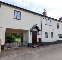 An exterior view of a building with windows and a gate at 1 Eastdon Cottages in Exeter