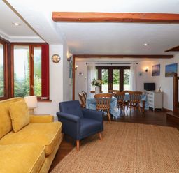 A living room with a sofa and dining area at 1 Eastdon Cottages in Exeter