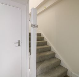 A hallway with stairs and a door at 21A High Street, Jedburgh