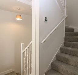 A staircase with carpet and a light fixture at 21A High Street in Jedburgh