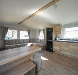 A living room with seating and kitchen appliances at Sand and Splash - Hayling Island