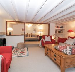 A living room with red chairs wooden coffee table and a small sitting area at Springfield in Kingsand