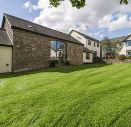 An outdoor view of a house with a lawn at Heathcliffe House, Caslteton near Cardiff