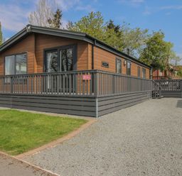 A house with a deck and grass area at Peony in Eardisland