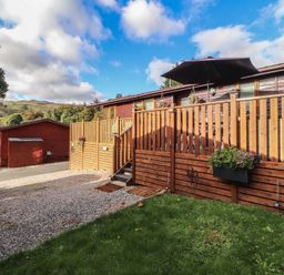 A decking area with steps and a planter at Swifts Reach Lodge, Kirkstone 10, Limefitt Park near Windermere