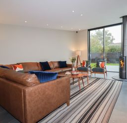 A living room with a sofa, chairs, and a fireplace at Harberton