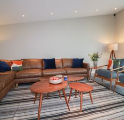 A living room with a sofa and coffee tables at Harberton