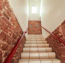 A staircase with stone walls and signage at The Hayloft near Wigton