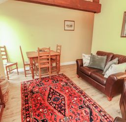 A living room with a table and chairs and a couch at The Hayloft near Wigton