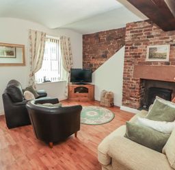A living room with a sofa and coffee table at The Coach House near Wigton