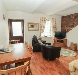 A living room with a dining table and chairs at The Coach House near Wigton