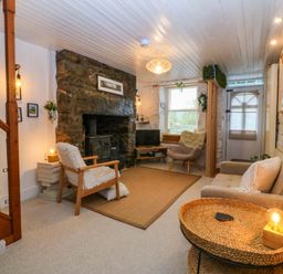 A living room with a fireplace and seating area at Waterfall Retreat in Blaenau Ffestiniog