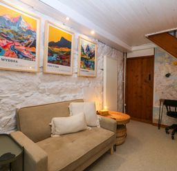 A snug with a sofa and posters on the wall at Waterfall Retreat in Blaenau Ffestiniog