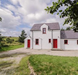 A cottage with red doors and windows at Shane's Cottage in Falcarragh, County Donegal