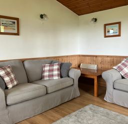 A living room with sofas and wooden table at Island View Lodge in Back of Keppoch near Arisaig