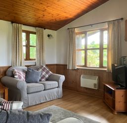 A living room with a sofa and television at Island View Lodge Back of Keppoch near Arisaig