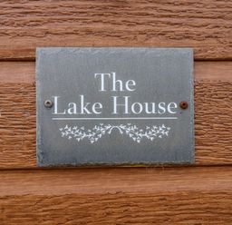 A sign reading The Lake House mounted on a wooden wall at The Lake House in Marston near Barkston