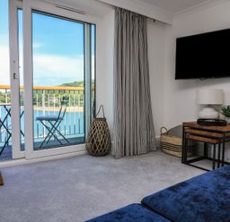 A living room with a sofa and a television at 43 The Salcombe in Salcombe