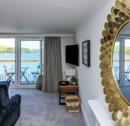 A living room with a view of the water at 43 The Salcombe in Salcombe
