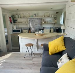 A kitchen with a countertop and seating area at The Cow Shed in Mawgan Porth