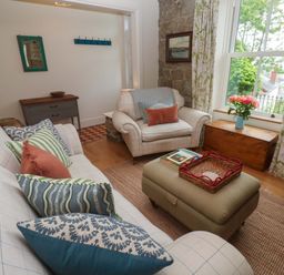A living room with a sofa, chair, and coffee table at Kittiwake in Penzance