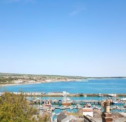 A scenic view of a harbor with boats and hills at Kittiwake Newlyn
