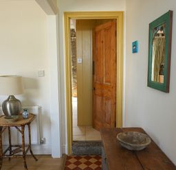 A hallway with a door and table at Kittiwake in Newlyn