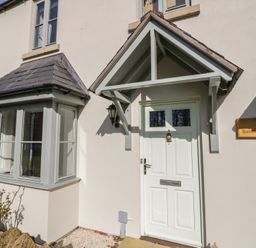 Front door entrance with a small porch and bay window beside it at 2 Summers Way in Moreton-In-Marsh