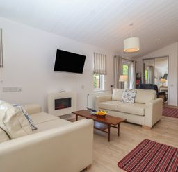 A living room with a sofa and television at Newton Calm in Newton Ferrers