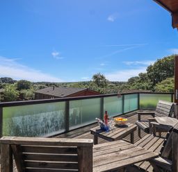 Outdoor seating area with wooden chairs and table at Skyview in Newton Ferrers