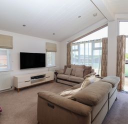A living room with a television and sofa at Skyview in Newton Ferrers