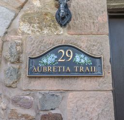 A house number plaque 29 Aubretia Trail on a stone wall at Aubretia Trail Akeld near Wooler