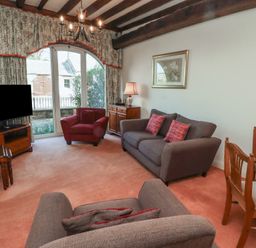 A living room with sofas a television and dining table at Aubretia Trail in Akeld near Wooler