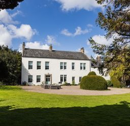 A house with a garden and trees at Cheviot Manor in Akeld near Wooler