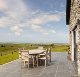 A patio with a table and chairs at Golygfa Cwrt near Bontgoch and Penrhyncoch