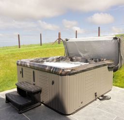 A hot tub with steps in an outdoor setting at Golygfa Cwrt Near Bontgoch and Penrhyncoch