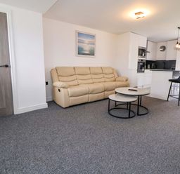 A living room with a sofa and coffee table at 4 Willow Grove - Freehold Talacre
