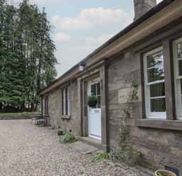 An outdoor area with a door and windows at Eagle Glen Cottage in Kettins near Coupar Angus