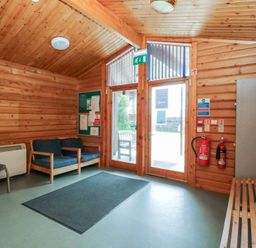 A lobby with seating and a notice board at Shore Lodge in Brodick