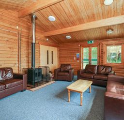 A living room with sofas and a fireplace at Shore Lodge in Brodick