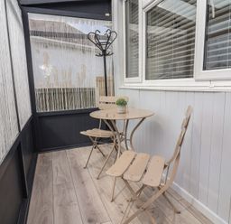A conservatory with a table and chairs at Driftwood in Rhyl