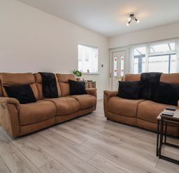 A living room with two sofas and a table at Driftwood in Rhyl