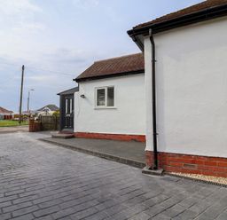 An exterior view of a house with a driveway at Driftwood in Rhyl