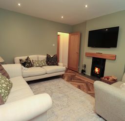 A living room with a sofa and fireplace at Highfield Cottage in Windermere