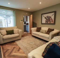 A living room with sofas and a painting at Highfield Cottage in Windermere