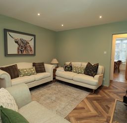 A living room with sofas and a rug at Highfield Cottage in Windermere