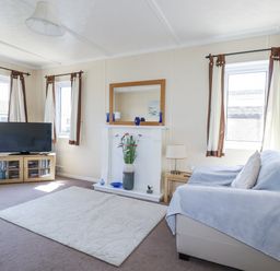 A living room with a television and sofa at Lazy Days in St Merryn