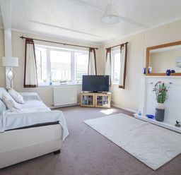 A living room with a sofa and television at Lazy Days in St Merryn