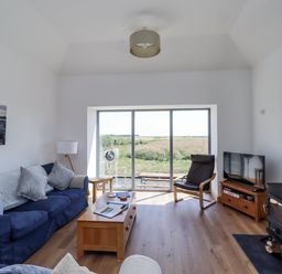 A living room with a sofa and television at West Burton Hemmel in Bamburgh