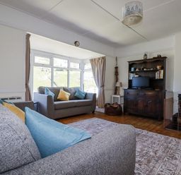 A living room with a sofa and television at Sea Ledge in Tintagel